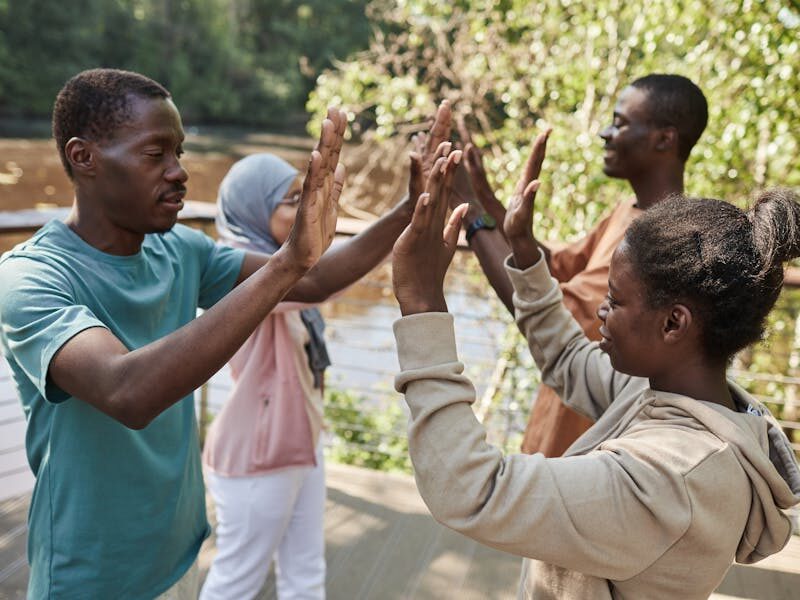 Two people sharing a high-five outdoors